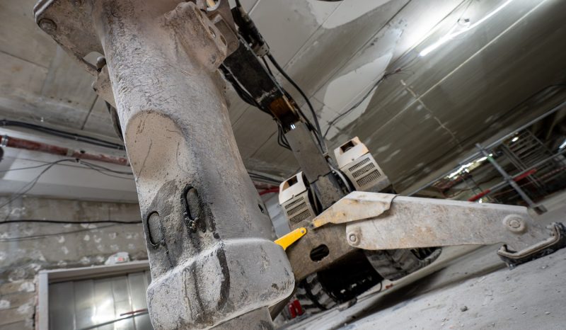 Robot de démolition équipé d’un marteau hydraulique intervenant sur un chantier intérieur SMB Bâtiment